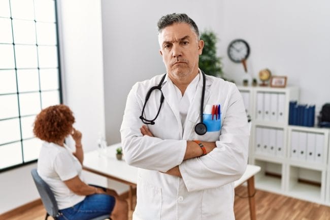skeptical doctor looking at a patient.