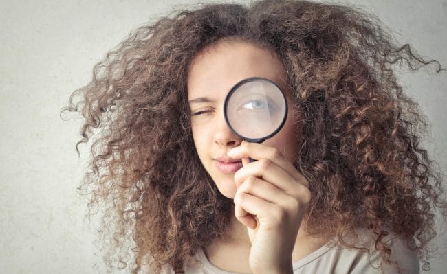 Woman Looking Through Magnifying Glass